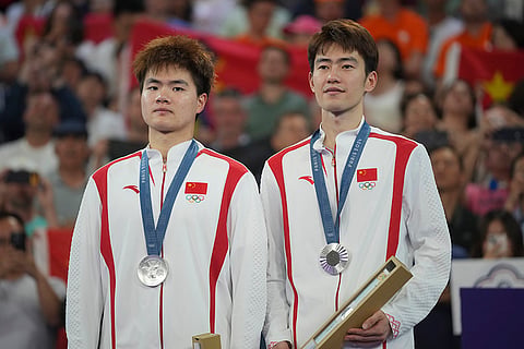 Badminton Men's doubles: China's Liang Weikeng, left, and Wang Chang after winning silver medal